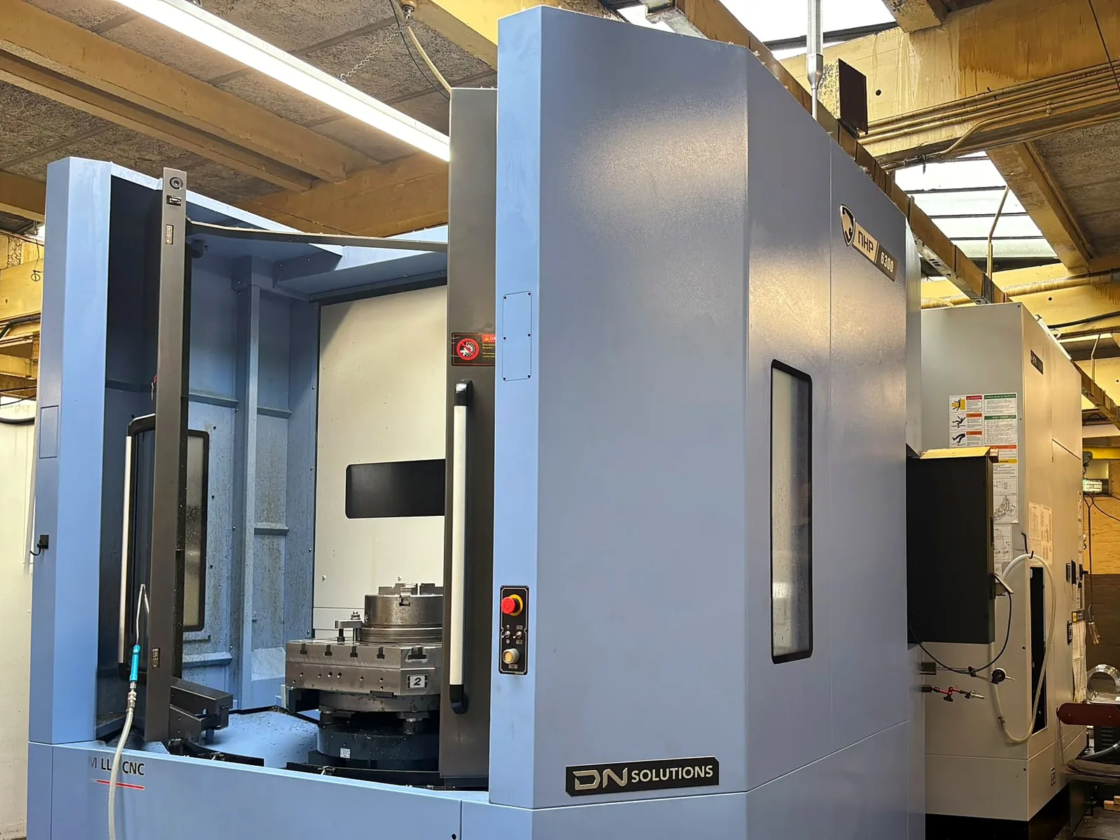 A DN Solutions NHP 6300 horizontal machining centre on the shop floor, its door open